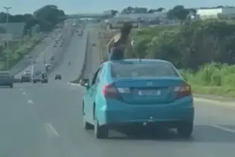 Passageira é flagrada no teto solar de carro, na BR-153 Passageira é flagrada no teto solar de carro, na BR-153